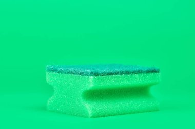 Temizlik, temizlik ve bulaşık yıkama için yeşil sünger. Yumuşak ve sert çift taraflı sünger. Asgari yeşil arkaplan, kopyalama alanı.