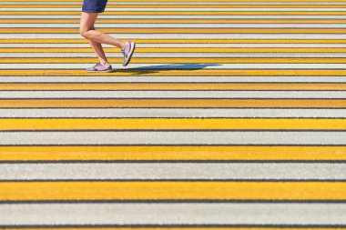 Yaya geçidinde koşan kadın, kopyalama alanı. Şehir yolunda spor kıyafetleriyle koşan atletik bir kadın. Sağlıklı yaşam tarzı, spor hobisi. Trafik ihlali. Sokak çalışması, açık hava koşusu.