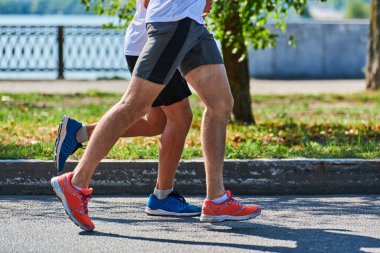 Koşan adamlar. Şehir yolunda spor kıyafetleriyle koşan spor adamları. Sağlıklı yaşam tarzı, spor hobisi. Sokak maratonu, açık hava koşusu.