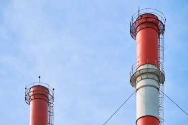 Fabrika bacası, kopyalama alanı. Kırmızı ve beyaz. Dumansız endüstriyel boru, zararlı emisyonlar. Açık mavi gökyüzü.