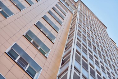 Çok katlı bir bina. Fotoğrafçılıkta ritim. Çok katlı cephe, pencereler ve apartman blokları, kapatın. Yüksek binadaki modern daireler. Bakış açısı.