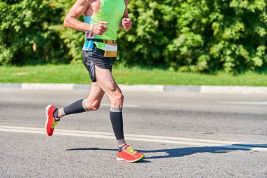 Koşan adam. Şehir yolunda spor kıyafetleriyle koşan atletik bir adam. Sağlıklı yaşam tarzı, spor hobisi. Sokak çalışması, açık hava koşusu.
