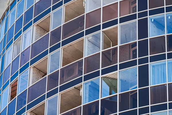 Multistorey building. Rhythm in photography. Multi-storey facade, windows and block of flats, close up. Modern apartments in high raised building. Angle perspective.