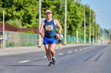 Voronezh, Rusya - 24.08.2019 - genç adam yol boyunca koşar. Koşu maratonu ve şampiyonluk yarışması, fotokopi alanı. Sokak dışarı koşuyor. Sağlıklı spor etkinliği.
