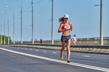 Voronezh, Rusya - 24.08.2019 - Genç kız yol boyunca koşar. Koşu maratonu ve şampiyonluk yarışması, fotokopi alanı. Sokak dışarı koşuyor. Sağlıklı spor etkinliği.