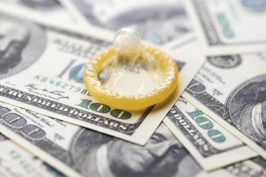 Prezervatif ve banknot. Fuhuş konsepti. Doğum kontrol hapı olan bir Amerikan doları. Gecelik seks için para öde. Fahişelik ve fahişelik..