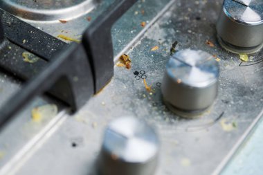 Kirli gaz ocağının tepesinde yemek artıkları var. Yağ lekeli kirli çelik mutfak ocağı. Bahar temizliği, eski mutfak yağ lekelerini, kızartma lekelerini, yağ lekelerini ve yanmış parçaları çıkarın.