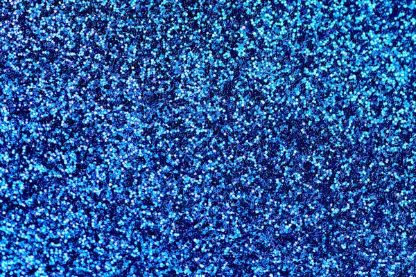 Blue glitter texture. New Year or christmas background for greeting card. Valentines Day celebration. Shiny sparkle design for festive decoration: wedding, holiday or anniversary party.