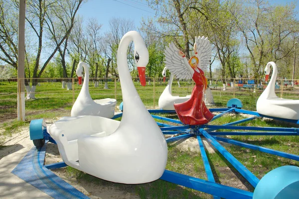 Kanatları açmak gibi ve büyük bir yıldız standları şeklinde bir kokoshnik kafasına bir kuğu ve uzun Rus Halk sarafan bir kız heykeli elbise eller çocukların atlıkarınca ortasında.                               