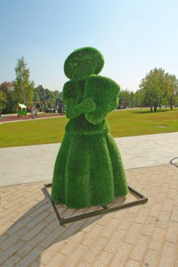 Yapay bir çimenlikten bir kadının topiary-peyzaj figürü. Çim yeşili, 23 Ağustos 2019, Zelenograd, Moskova, Rusya.