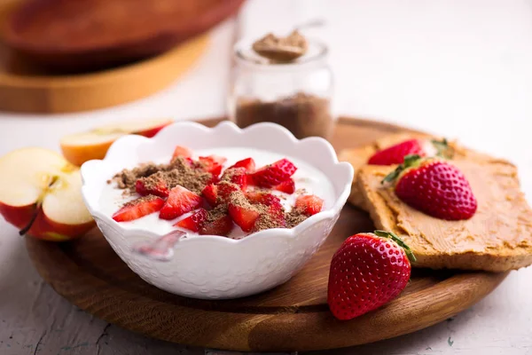 Natural yogurt with strawberries, peanut butter toast and apple.. healthy breakfast..selective focus