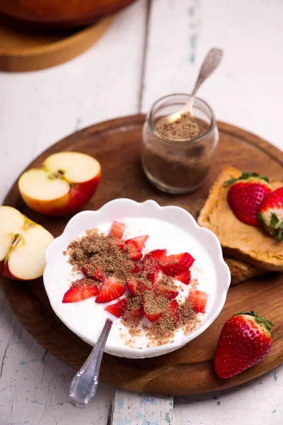 Natural yogurt with strawberries, peanut butter toast and apple.. healthy breakfast..selective focus