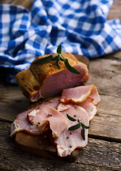 Il taglio una carne di maiale affumicata su un tavolo di legno — Foto Stock