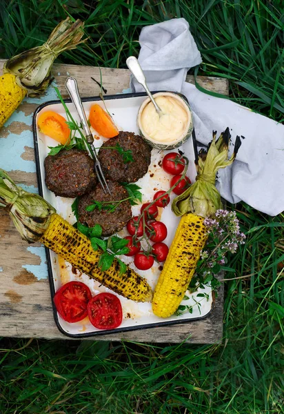 Barbecue lam hamburgers met groenten en maïs. — Stockfoto
