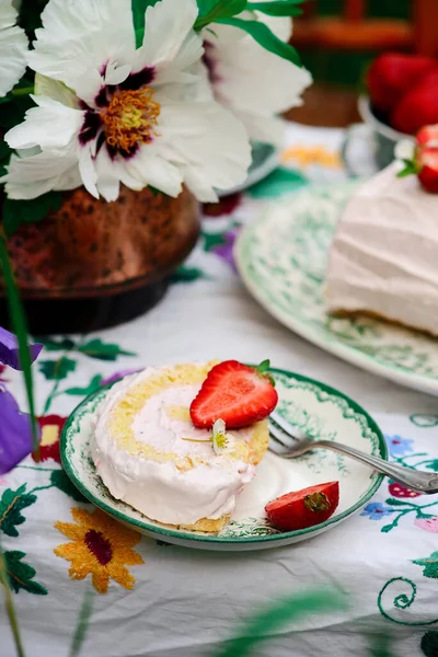 夏の庭をイメージしたテーブルの上にイチゴとクリームがのったスポンジロール ヴィンテージスタイル — ストック写真