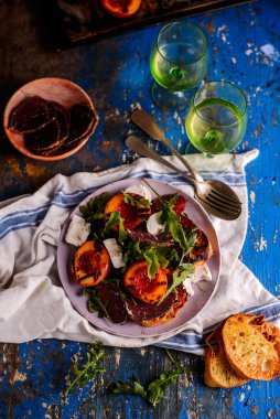 Izgara şeftali, keçi peyniri ve bresaola salatası. Seçici odak noktası.