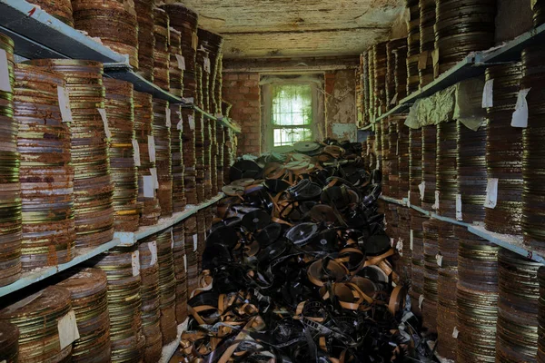 Destroyed from time to time storage room with stored old rusty round boxes with old film