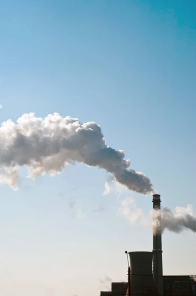 Industrial chimneys with heavy smoke causing air pollution.