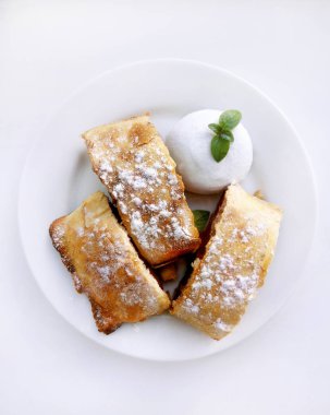 Bir parça turta, elma, kiraz, dondurma ve nane bir beyaz ile bir pasta plaka, beyaz arka plan yuvarlak, bir mutfak pişirme tarifi için fotoğraf.