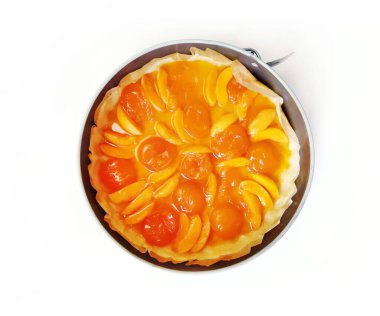 Kayısı turtası, yaz meyveli kek, yuvarlak bir fırın kabında, beyaz arka planda izole edilmiş. Üst görünüm