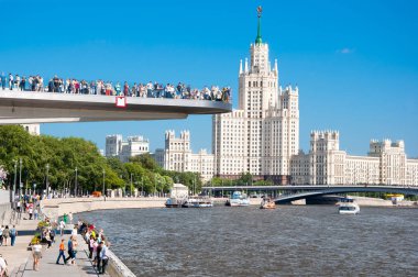 Moskova, Rusya-Mayıs 27,2018: yüzen köprü tam ziyaretçi Zaryadye Park Kotelnicheskaya dolgu ve Moskova Nehri üzerinde Kotelnicheskaya bina uzaktan görünür.