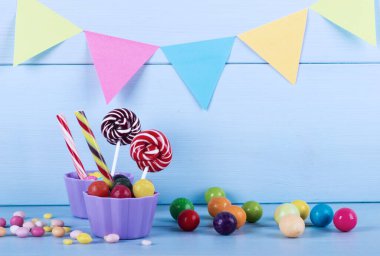 Renkli lolipoplar, baston şekerler ve tatlı şekerler ahşap arka planda karıştırılır.