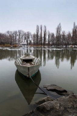 Yalnız tekne bir kış nehir kıyısında kıyıya bağlı