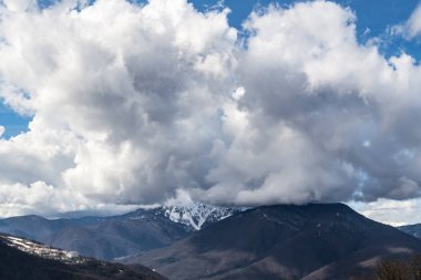 Şapkalı kar dağlar kalın bulutlar ile kaplıdır