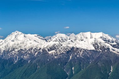 Karlı dağ başında mavi gökyüzünde bulutlar ile