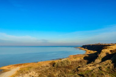 Küçük kayalık lagün ve kıyı çim ile deniz plaj. Derin mavi gökyüzü. Rusya Azak Denizi.