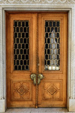 Masif bronz kolları ile eski ahşap oyma kapı