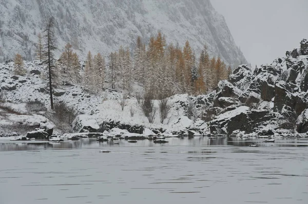 Cloudy morning. Snow-covered winter mountain lake, Russia, Siberia, Altai mountains, Chuya ridge.