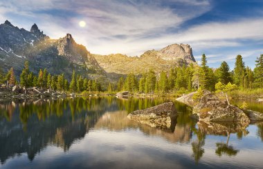 Yaz sabahı küçük göl üzerinde. Güneş ışınları bulutlar arasında Parlatıcı. Ergaki doğa parkı. Krasnoyarsk bölgesi Rusya