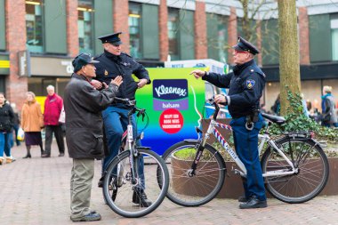 Delft, Hollanda - 18 Ocak 2014: Delft, Hollanda bir adam ile tartışmaya meşgul bir meydanda bir bisiklet üzerinde iki dostu Hollandalı polis memuru