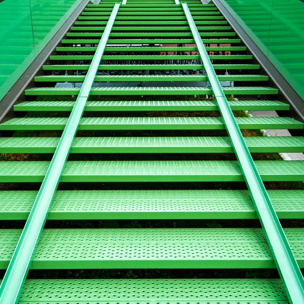 Bicycle gutter on a modern steel green staircase in a bicycle parking in the Delft univerity campus, Netherlands.