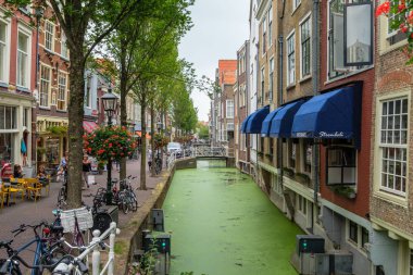Restoran, turistler ve evlerin sağda canal, Delft, Hollanda Voldersgracht alışveriş.