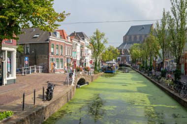 Güzel eski duckweed ile kanal ve bir teras tekne ve Delft, Hollanda 2 eski Köprüsü bakmak. İskele boyunca çok sayıda bisiklet ve rahat mağazanın.
