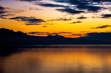 Güzel renkli gün batımı Fransız Alpleri ve fantastik turuncu parlak siluetleri ile sonbahar renkleri İsviçre Cenevre Gölü üzerinde yansıyan.