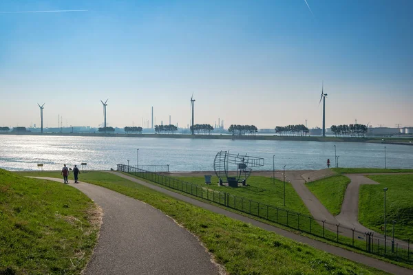 Due persone che camminano sulla diga verso il nuovo corso d'acqua, accesso al porto di Rotterdam, Paesi Bassi — Foto Stock