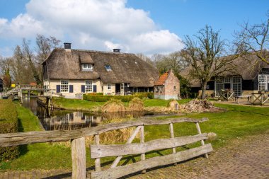 Erken bahar Giethoorn, Hollanda üzerinde her yerde, kanallar ve güzel rustik thatched çatı çiftlik evi ve ahşap köprü ile geleneksel bir Hollandalı köy görüntüleyin.