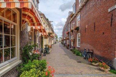 Delft eski şehir merkezinde çiçekler ile çok güzel eski sokak, Hollanda
