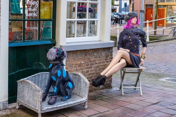 Renkli kadın ve köpek bir caddenin köşesinde oturan rakamlar yatıyordu Delft, Hollanda — Stok fotoğraf