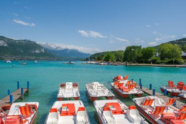 Parkiskele ve turistlerüzerinde pedallı tekneler ile Annecy Gölü, Fransa, güneşli bir görünüm