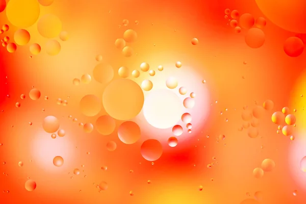 Pomarańczowe kręgi kropli oleju pływające po wodzie — Zdjęcie stockowe