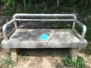 Mavi kapaklı kitap bankta yatıyor.