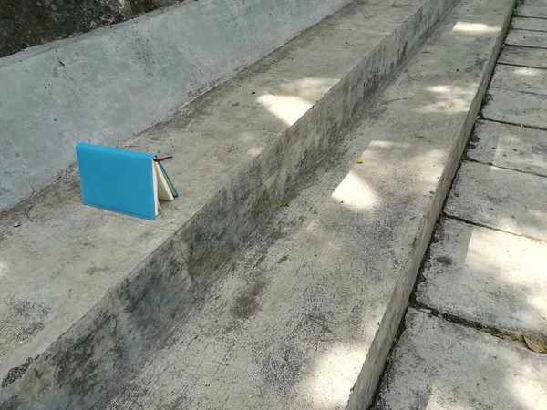 Beton merdivenlerde mavi defter