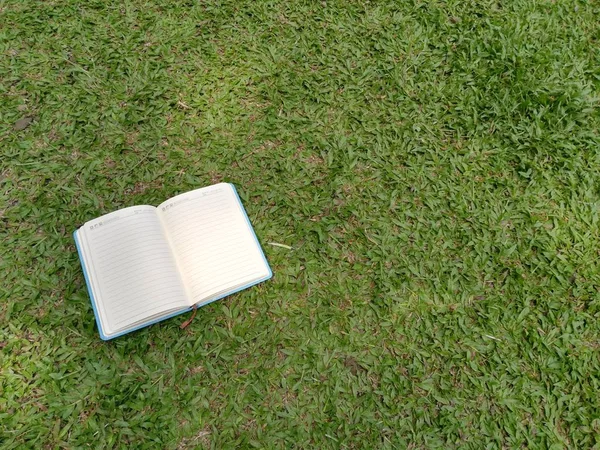 Masanın üzerinde boş beyaz bir kağıt olan açık bir kitap. Eğitim ve bilgi kavramı