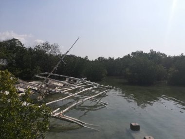 Nehir koyunda batan balıkçı teknesinin gündüz çekimi.