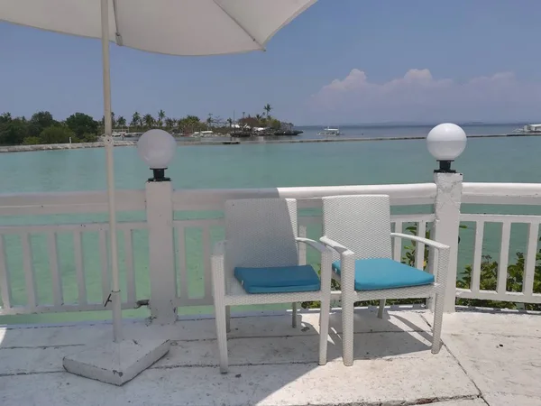 Beyaz sandalyeli ve mavi gökyüzü olan güzel sahil beldesi 