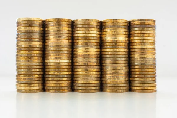 Gri zemin üzerine altın sikke yığını.